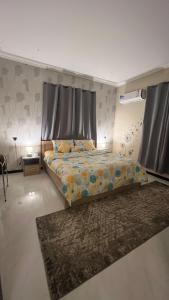 a bedroom with a bed with a curtain and a rug at ليلك lilac in Abha