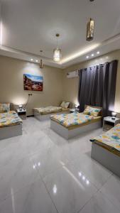 a room with three beds in a room with at ليلك lilac in Abha