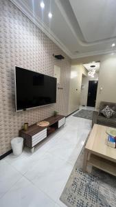 ein Wohnzimmer mit einem großen Flachbild-TV an der Wand in der Unterkunft ليلك lilac in Abha