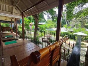 a wooden porch with a bench on a deck at Riddim Garden in Ko Samed