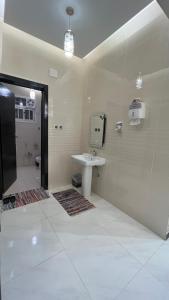 ein Badezimmer mit einem Waschbecken, einem WC und einem Spiegel in der Unterkunft ليلك lilac in Abha