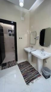 ein Bad mit 2 Waschbecken und einer Dusche in der Unterkunft ليلك lilac in Abha