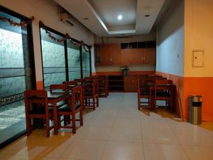 a dining room with wooden tables and chairs and windows at RedDoorz Near Jalan Jendral Sudirman in Manado