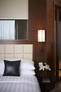 香港的住宿－香港觀塘帝盛酒店，一间卧室配有一张床和一张带台灯的桌子