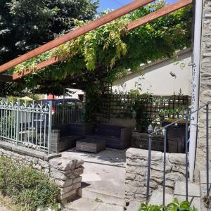 a pergola with ivy on the side of a house at Gite de Sarah 