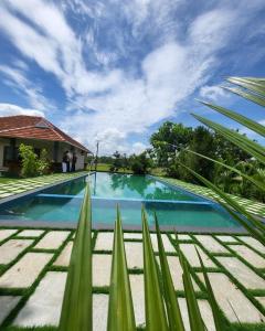 a swimming pool in front of a house at KOTTACKAL NATURE INN in Angamaly