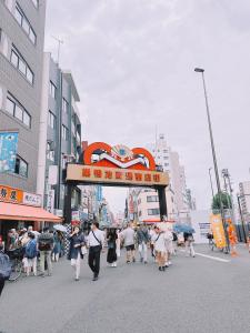 una multitud de personas caminando por una calle de la ciudad en 桜の川2 Sugamo Diamond mansion 206 direct to Ikebukuro Yamanote line 5mins en Tokio