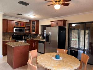 a kitchen with a table and a refrigerator at Entire Single Family home 3 bed 2 bath in water front big cozy back yard view in Coconut Creek