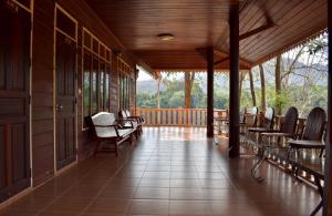 a screened in porch with chairs and a wooden ceiling at Baanpufa Resort in Sai Yok