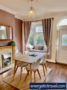 een eetkamer met een tafel en stoelen en een bank bij URBAN CITY SUITES 4 bed house, garden, Ideal for Contractors&Families in Quinton