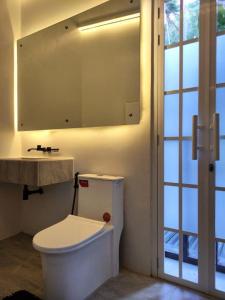 a bathroom with a toilet and a sink and a mirror at Puerto Galera Home in Balatero