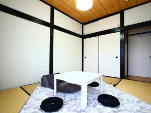 Cette chambre comprend une table blanche et un lit. dans l'établissement Oasis Wadaura, à Minamiboso