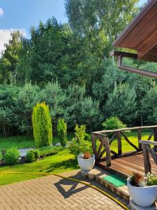 una terraza de madera con 2 macetas en un jardín en Privatus namas en Šilutė