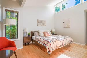 um quarto com uma cama, uma cadeira e janelas em Sunlit contemporary Bellevue Home w a Lush Garden em Bellevue