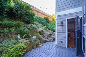 una pasarela de madera que conduce a una casa con puerta en Sunlit contemporary Bellevue Home w a Lush Garden en Bellevue
