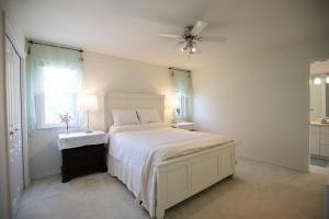 a white bedroom with a bed and a ceiling fan at Star of the Sea guest house in White Rock