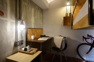 Zimmer mit einem Schreibtisch, einem Stuhl und einem Fahrrad in der Unterkunft Hualien Wow Hostel in Hualien