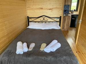 Una cama en una habitación de madera con zapatillas. en Cottage kazbegi sioni, en Kazbegi