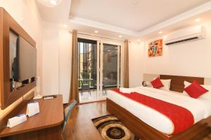a hotel room with a bed and a television at The Altruist Business Stays , DLF Phase 3 in Gurgaon