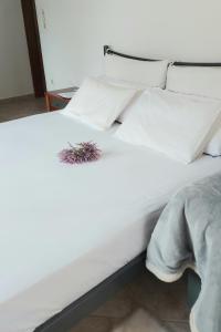 Una cama blanca con dos plantas encima. en FBM Anagenessis - Ευ Ζην en Edessa