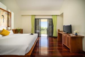 a bedroom with a large bed and a television at Palm Boutique Village - STAY 24H in Hoi An