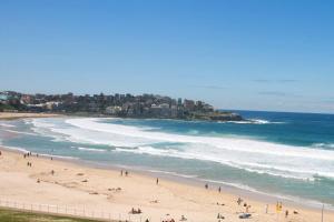 a group of people on a beach near the ocean at Bondi 38 Serviced Apartments in Sydney