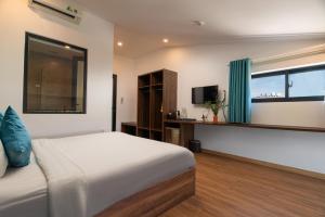 a bedroom with a bed and a window and a television at Hoianese Hotel - Lip Lip Pool Villa in Hoi An