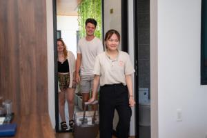 a man and a woman standing in a hallway with luggage at Hoianese Hotel - Lip Lip Pool Villa in Hoi An