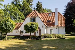 une maison blanche avec un toit rouge dans l'établissement Stylish villa 12p with private pool in the Veluwe, à Garderen