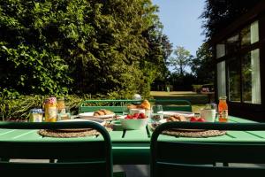 een groene tafel met eten erop bij Stylish villa 12p with private pool in the Veluwe in Garderen