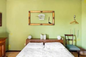 1 dormitorio con 1 cama con espejo y silla en Selvatica50 b&b, en Nonantola