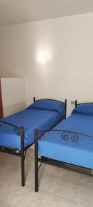 dos camas sentadas una al lado de la otra en una habitación en La Perla nel Blu en Villasimius
