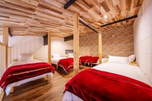 a room with three beds with red and white sheets at 千葉地域ランキング1位獲得の贅沢な貸別荘全4棟 