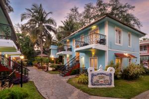 una casa azul con un cartel delante en Aldeia Santa Rita - Candolim, en Candolim