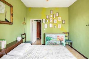 NonantolaにあるSelvatica50 b&bの大きなベッド付きのベッドルーム1室、壁に絵画が飾られています。