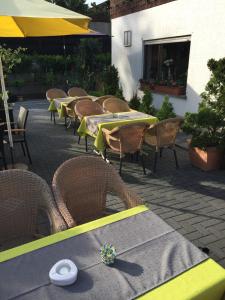 a row of tables and wicker chairs in a patio at Urberacher Hof in Rödermark