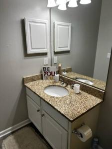 a bathroom with a sink and a mirror at Extravagant 2 BR/2 BA Apartment in Savannah