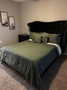 a bedroom with a large bed with a black headboard at Extravagant 2 BR/2 BA Apartment in Savannah