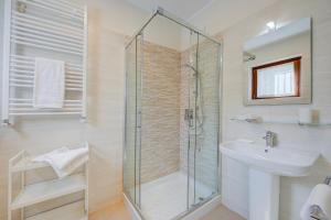 a bathroom with a glass shower and a sink at Cottage Del Lago - Happy Rentals in Laveno