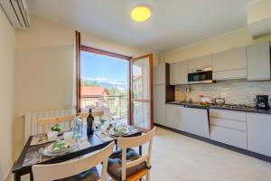 Cottage Del Lago - Happy Rentals في لافينو: مطبخ وغرفة طعام مع طاولة وكراسي