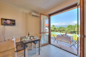 a dining room with a table and a balcony at Cottage Del Lago - Happy Rentals in Laveno-Mombello
