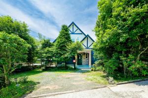 a blue house with a blue door and trees at AsoSweet in Aso