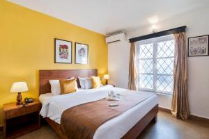 una camera da letto con un letto grande e una finestra di Aldeia Santa Rita - Candolim a Candolim Altre 25 foto