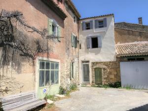 een bakstenen gebouw met een witte deur en een garage bij Village house of Jean in Gordes