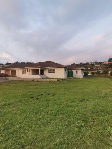 a house with a green field in front of it at Phakathi Lifestyle Village Umnini in Amanzimtoti