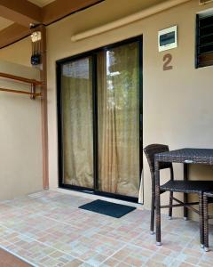 a screened in porch with a table and chairs at Anahaw Seaside Inn in Bantayan Island