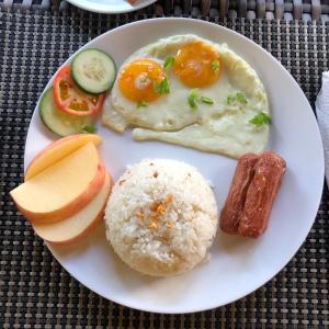 a white plate of food with eggs rice and vegetables at Anahaw Seaside Inn in Bantayan Island