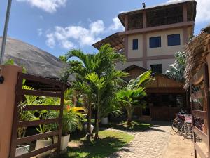 un bâtiment avec des palmiers en face de celui-ci dans l'établissement Anahaw Seaside Inn, à Île Bantayan