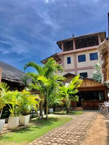 a resort with palm trees in front of a building at Anahaw Seaside Inn in Bantayan Island