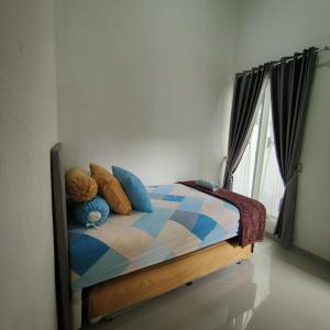 a bedroom with a bed with pillows and a window at Kayana Regency F7 in Batu